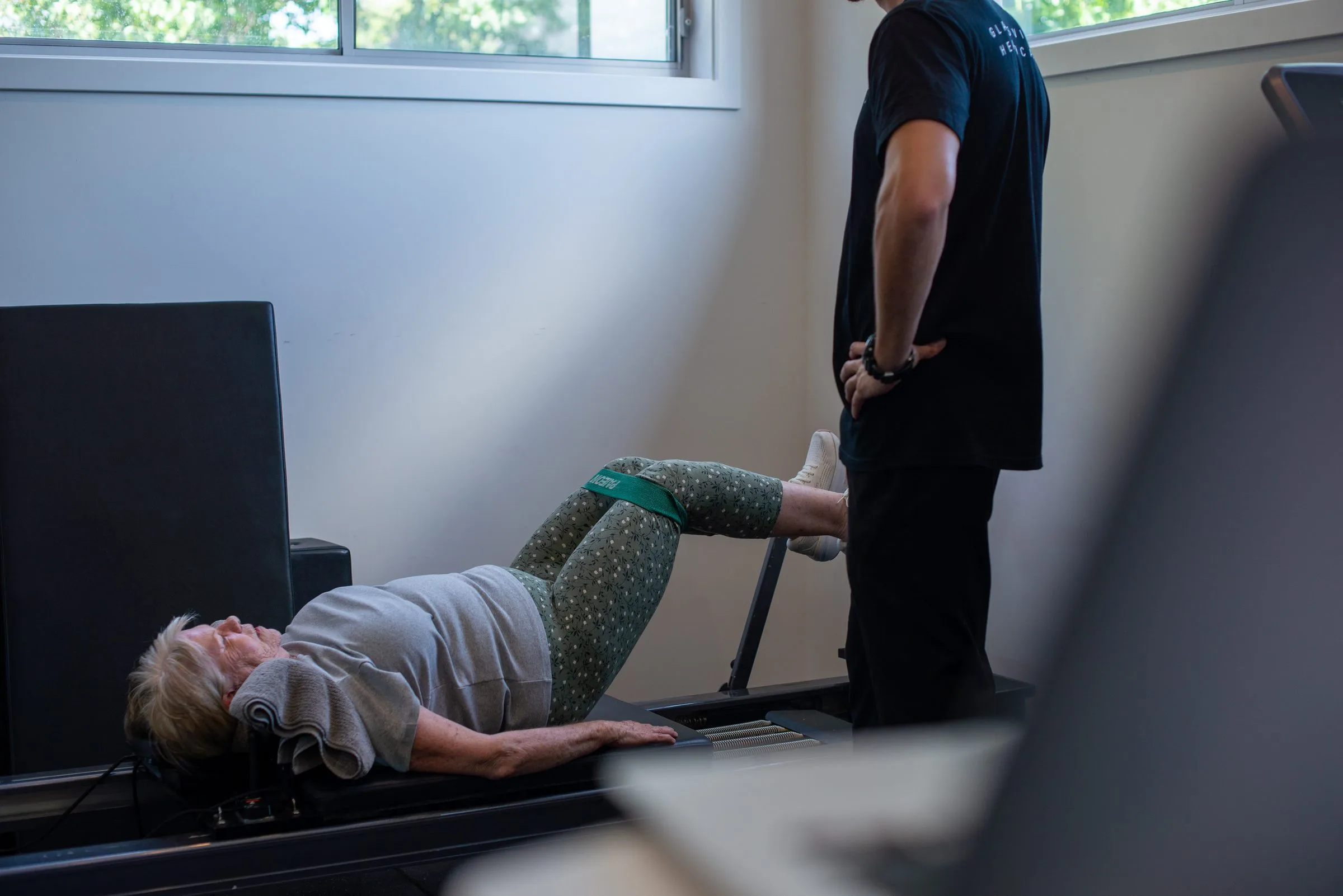 Exercise physiologist guiding a client through a movement to help manage pain
