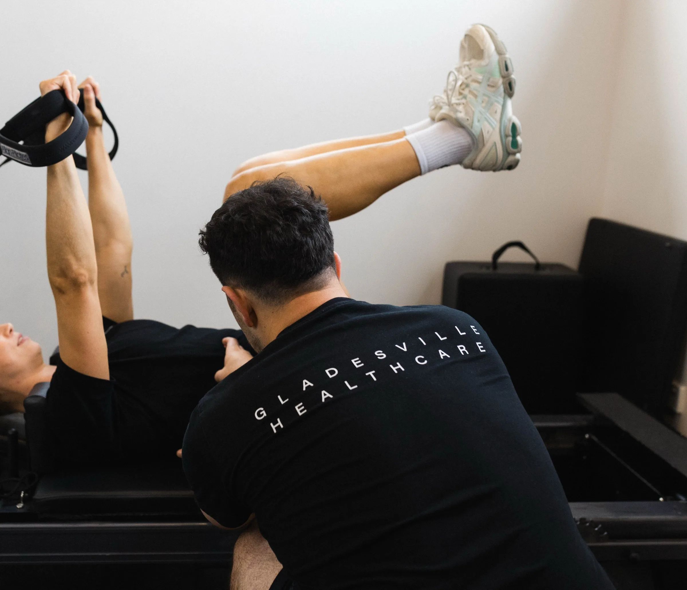Practitioner guiding a patient through a reformer exercise