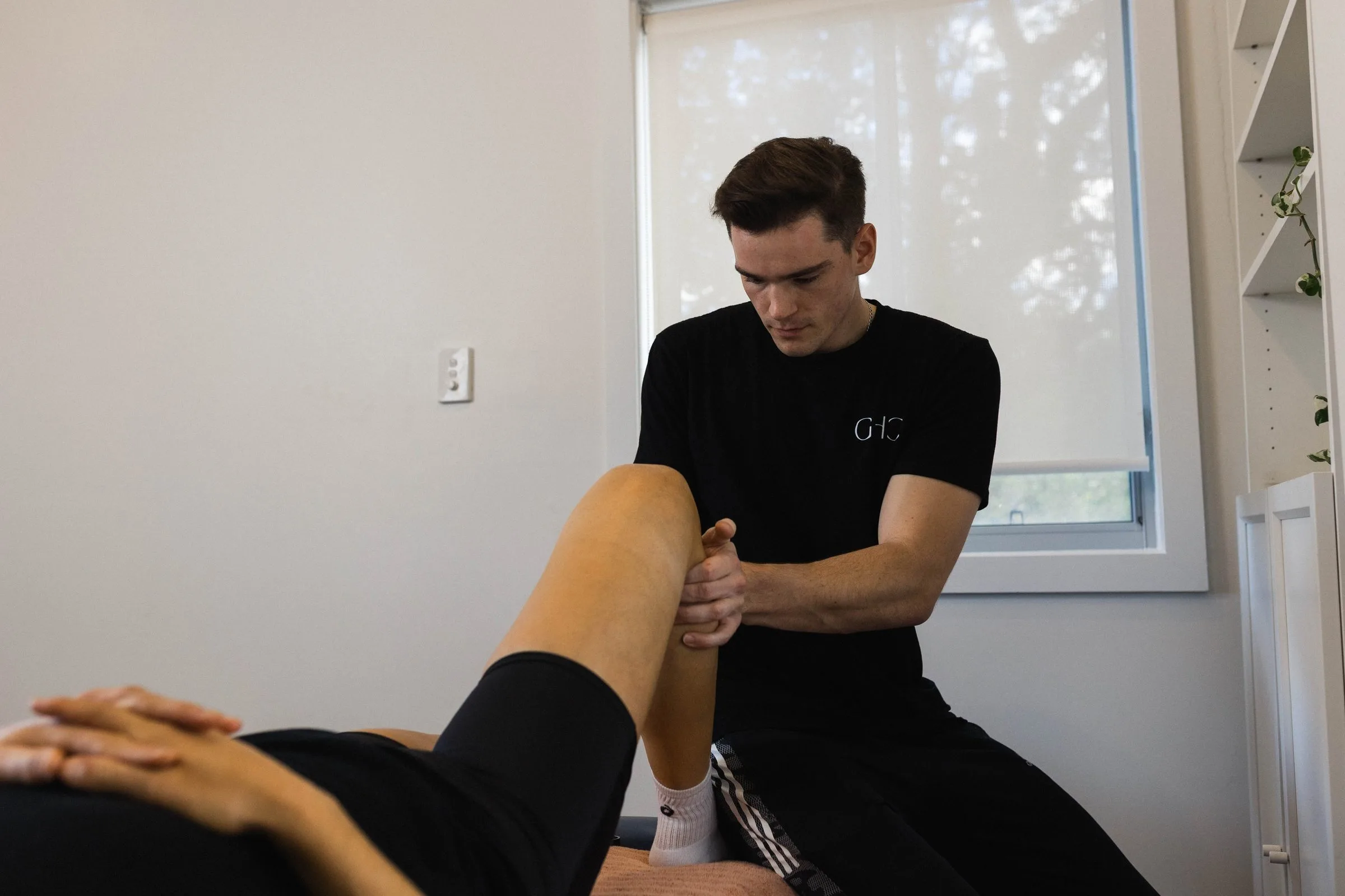 Physiotherapist mobilising a patient's joint on the treatment couch