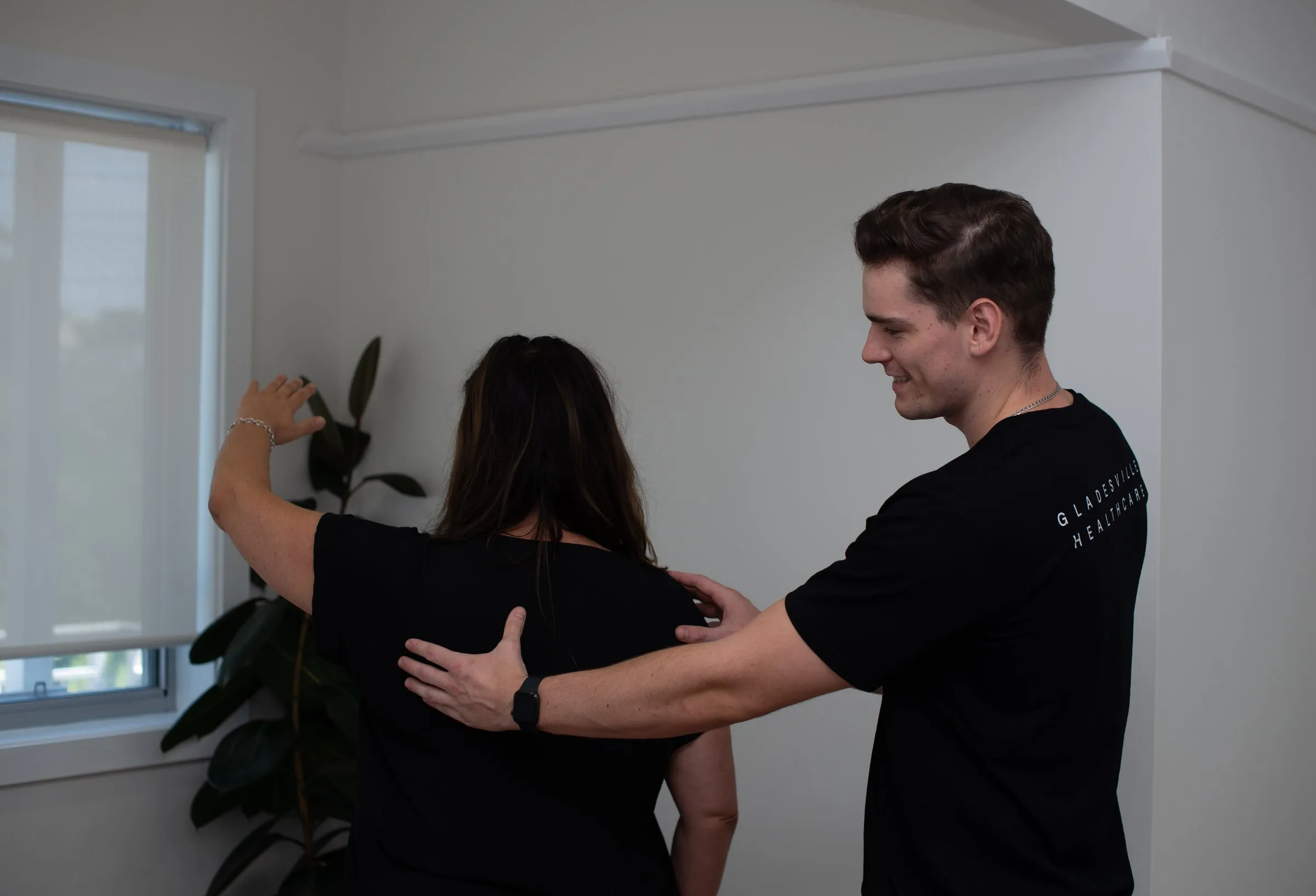 Practitioner at Gladesville Healthcare assessing a patient’s shoulder and upper back movement