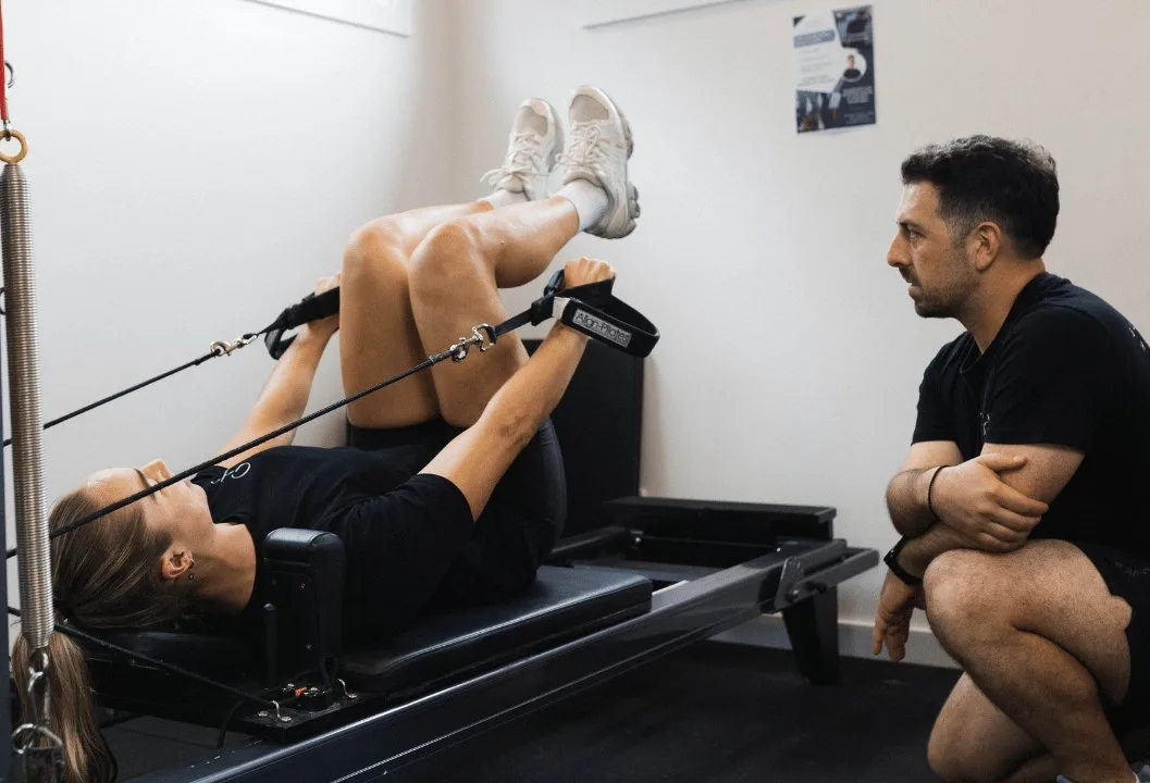 Exercise physiologist coaching a client on the reformer