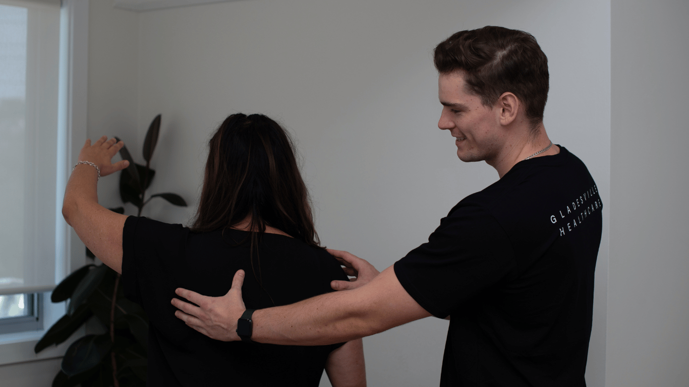 Male physiotherapist assessing female patient shoulder movement